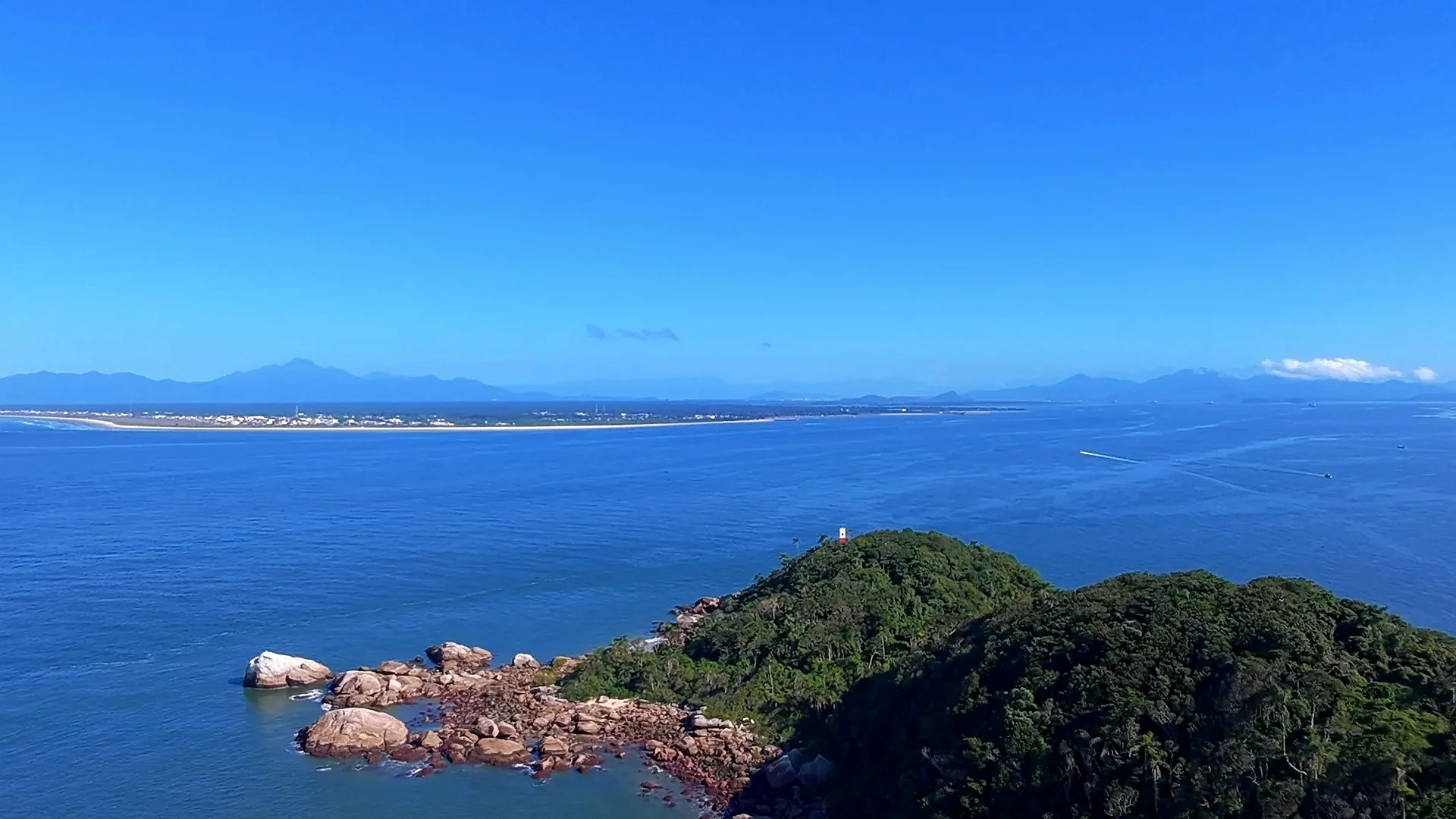 Imagem de drone aérea há mais ou menos 300 metros de altura onde conseguimos ver no Horizonte o ponto de travessia entre entre a Ilha do Mel e Pontal do Paraná